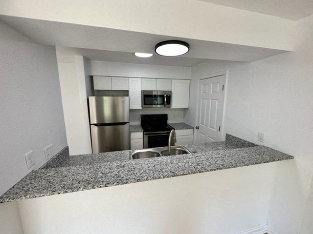 a kitchen with granite counter tops and stainless steel appliances at Mammoth at the Orchard Apartments, Rogers, 72756  