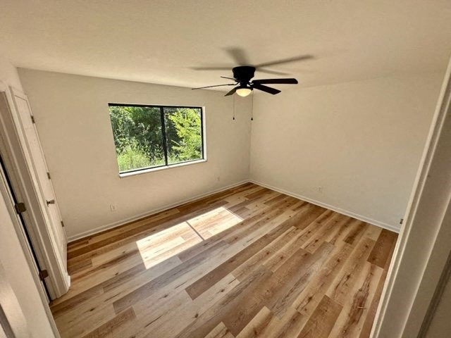an empty room with a ceiling fan and a window