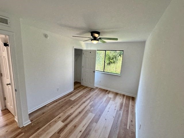 an empty room with a ceiling fan and a window
