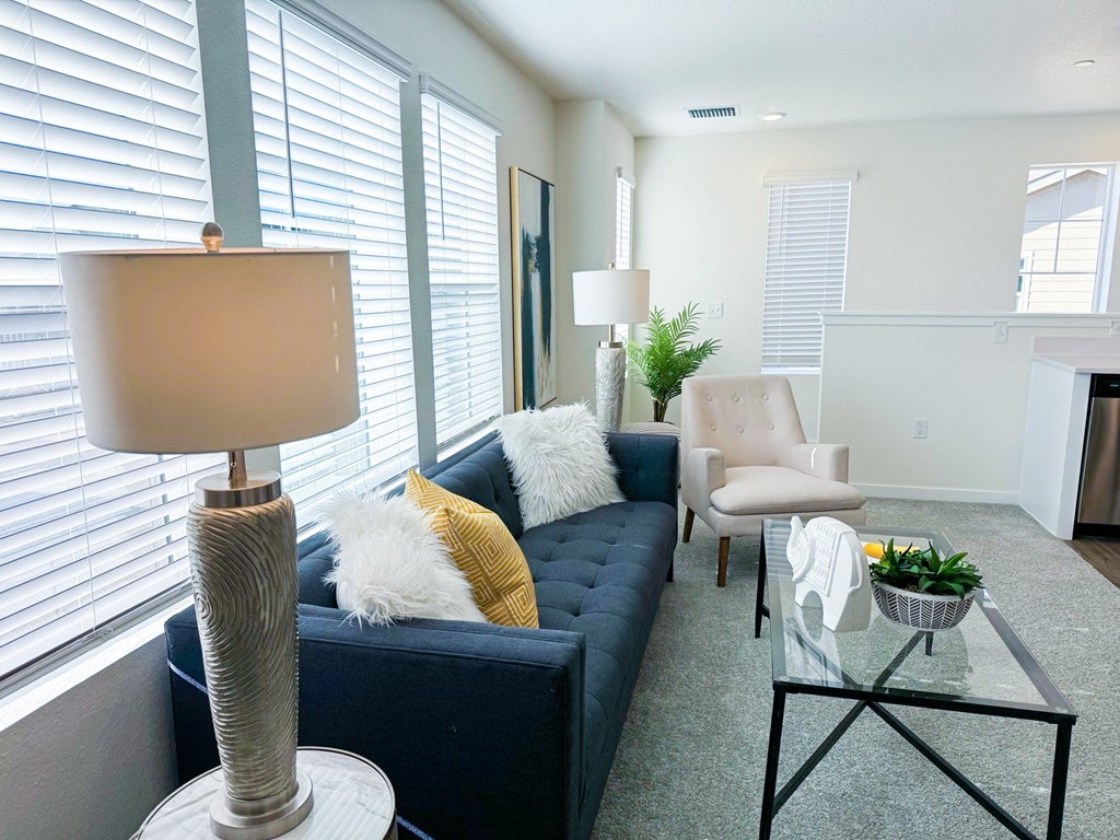 a living room with a blue couch and a glass coffee table