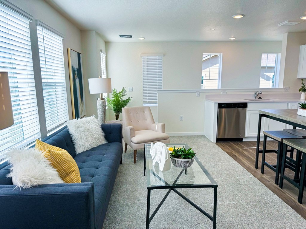 a living room with a blue couch and a glass coffee table