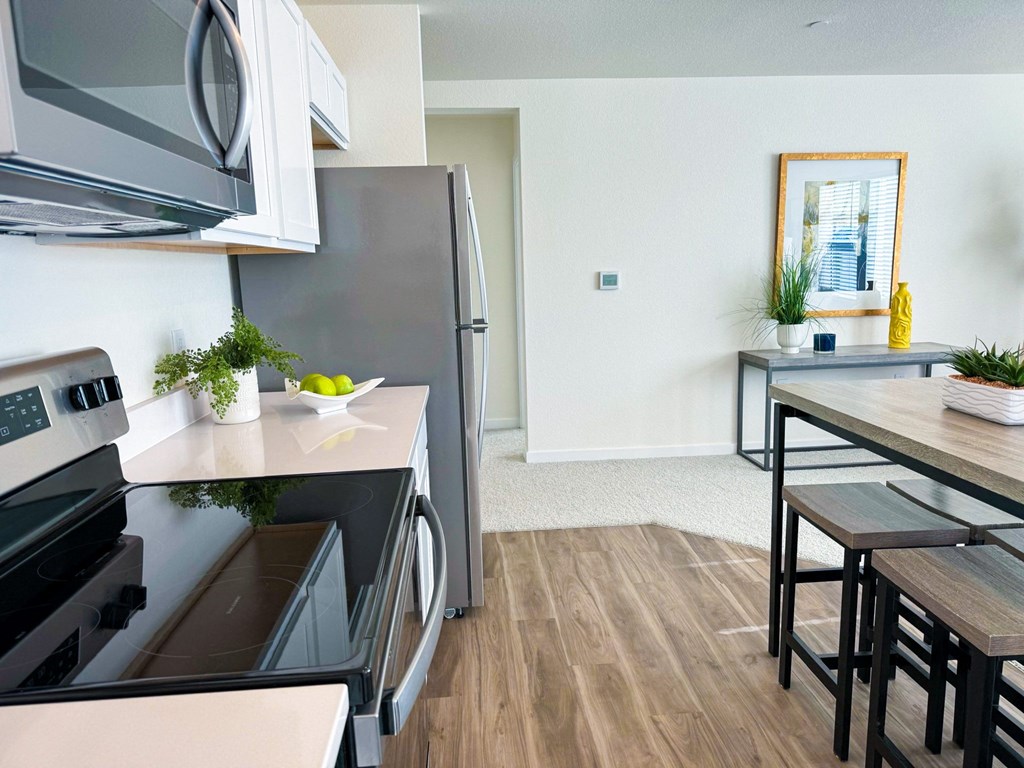 a kitchen and dining room with stainless steel appliances and a wooden floor
