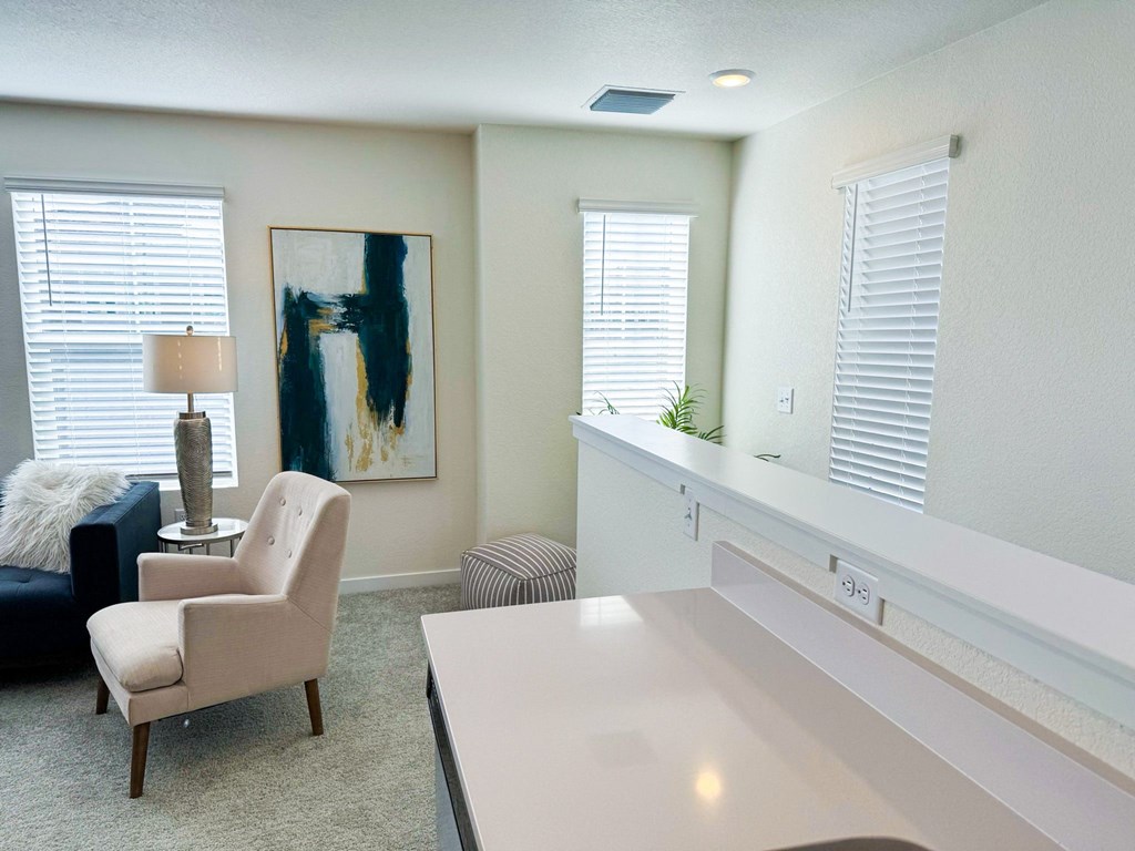 a living room with white furniture and a white counter top