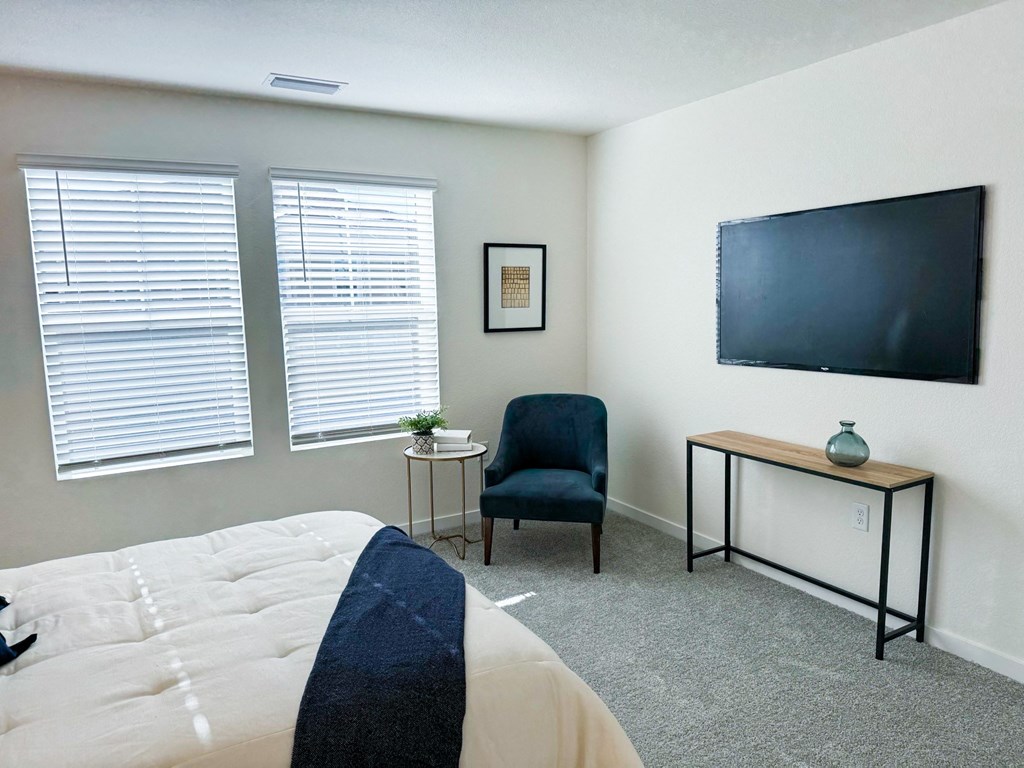 a bedroom with a bed and a tv on the wall