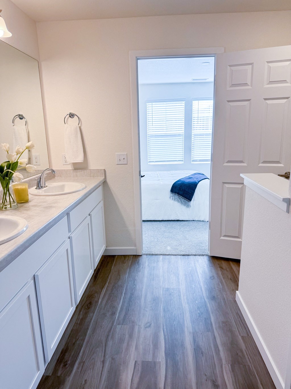 a bathroom with two sinks and a door to a bedroom