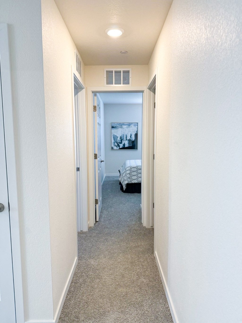 an empty hallway with a bed in the end of the room