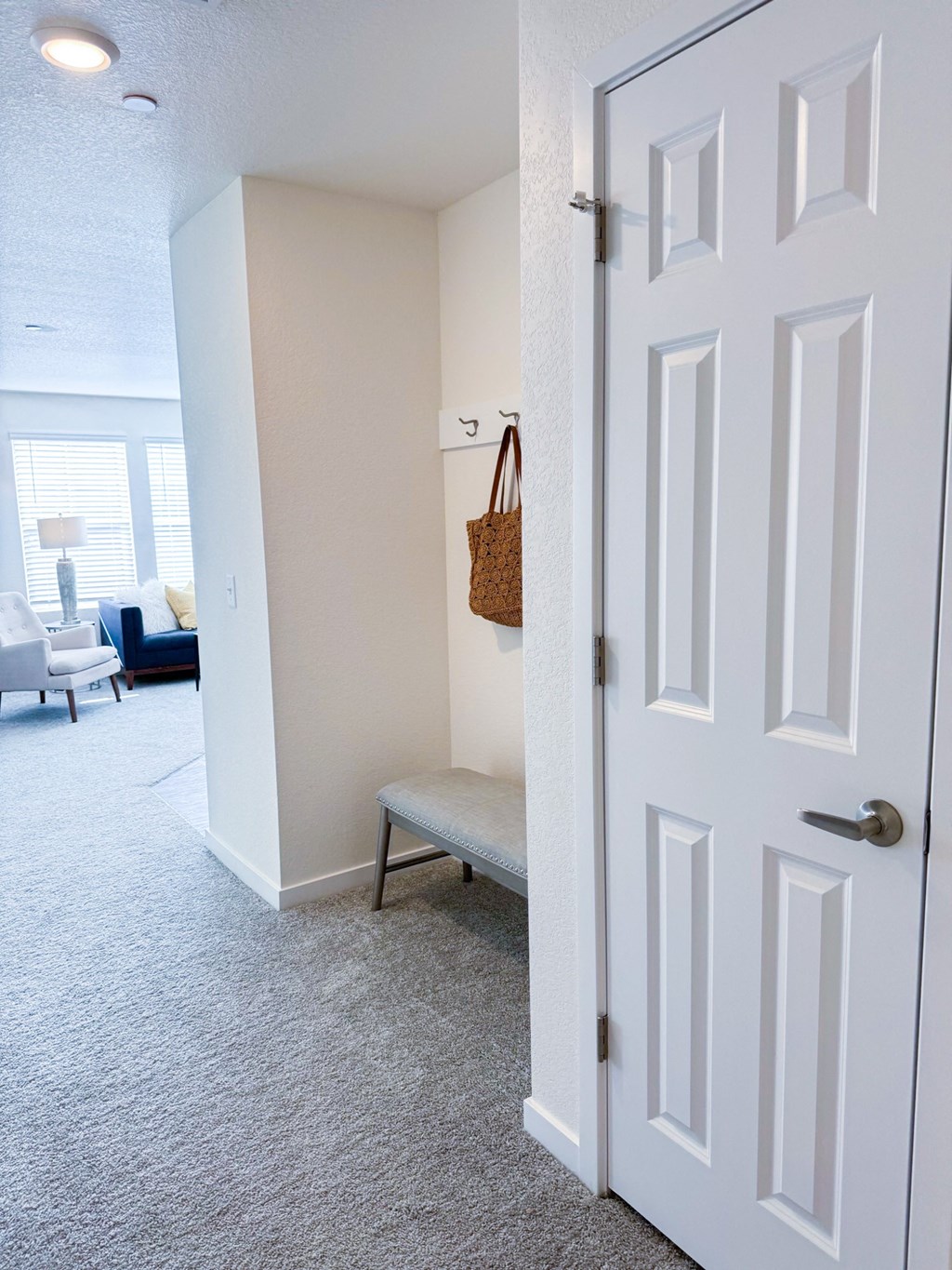 an open door leading into a living room with a chair and a closet