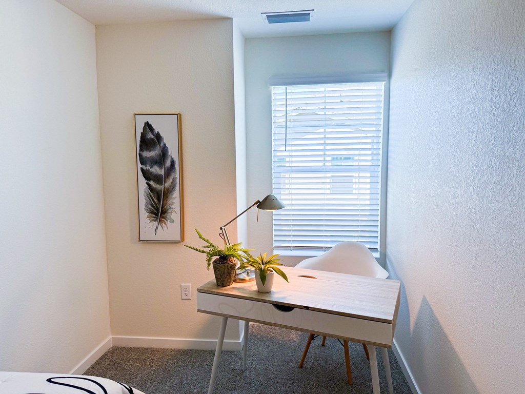 a home office with a desk and a window