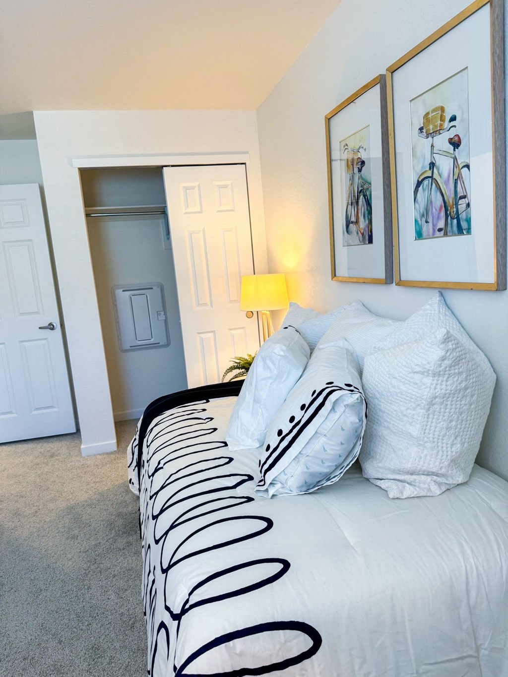 a bedroom with a bed and two pictures on the wall