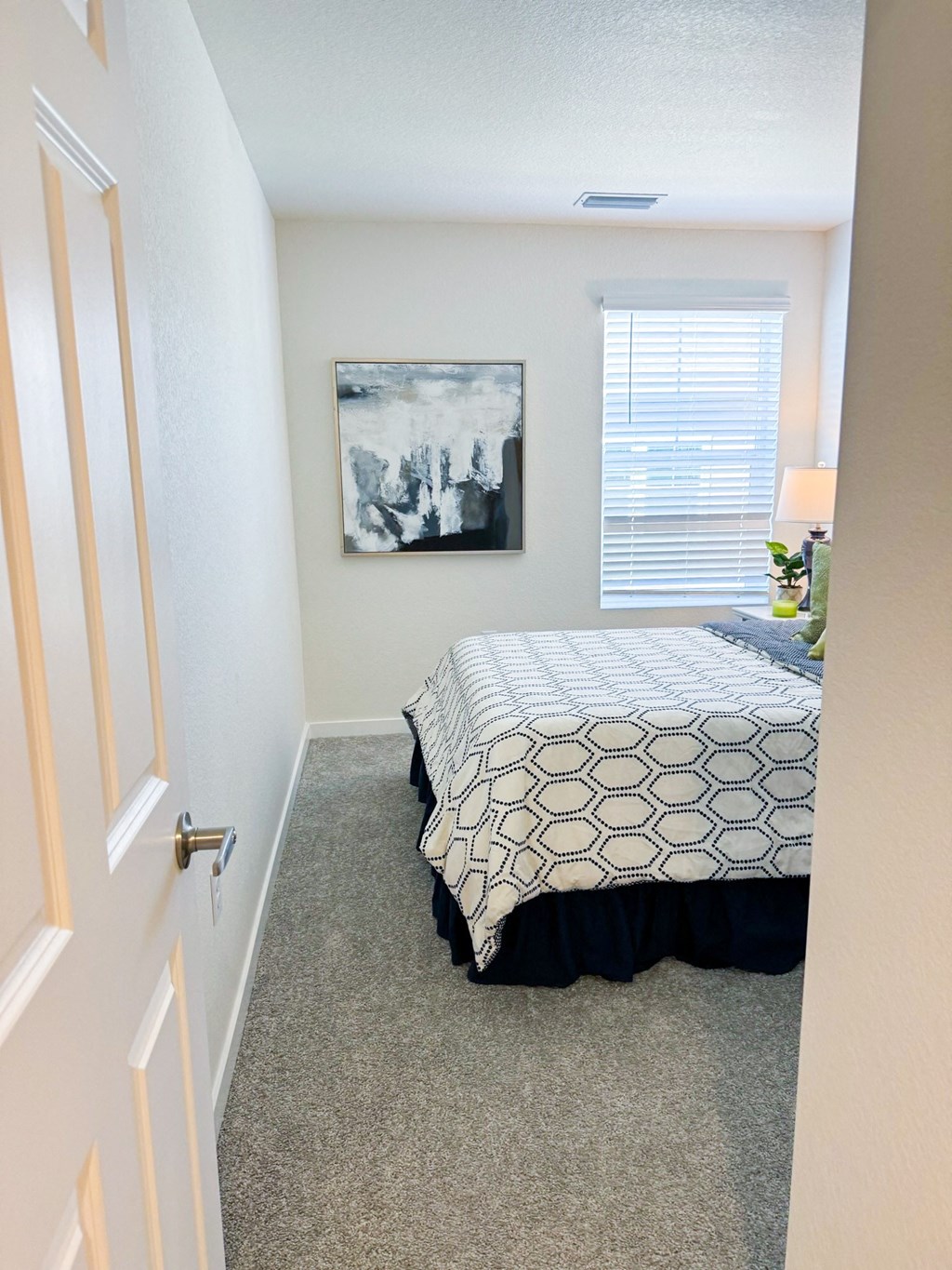 an empty bedroom with a bed and a window