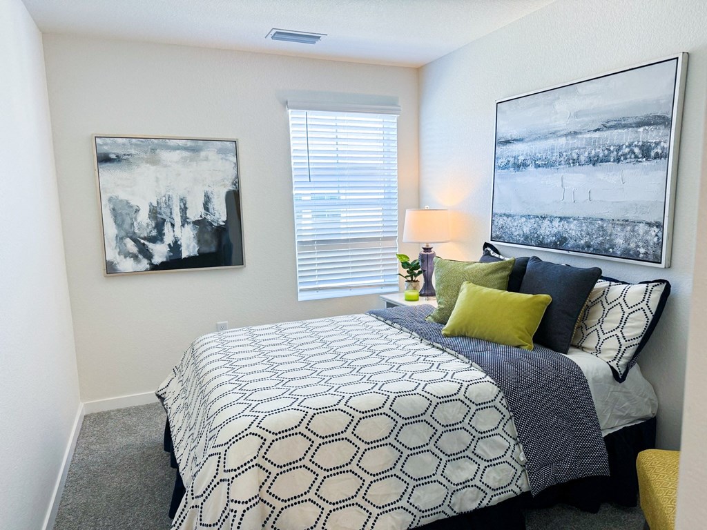a bedroom with a bed and pictures on the wall