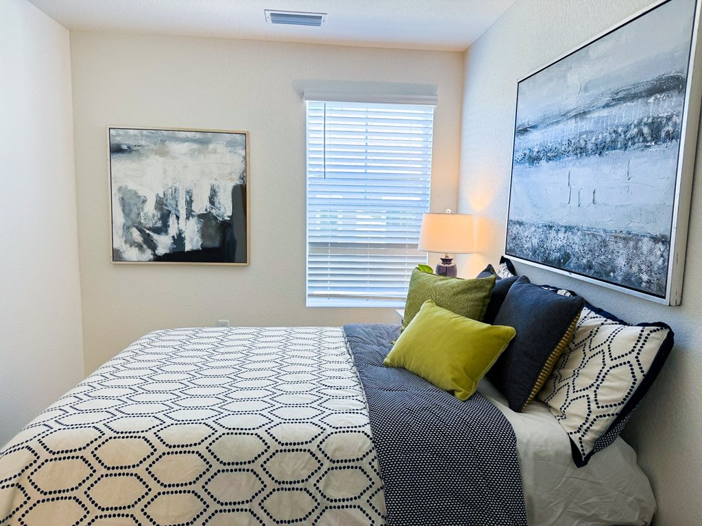 a bedroom with a bed and two pictures on the wall