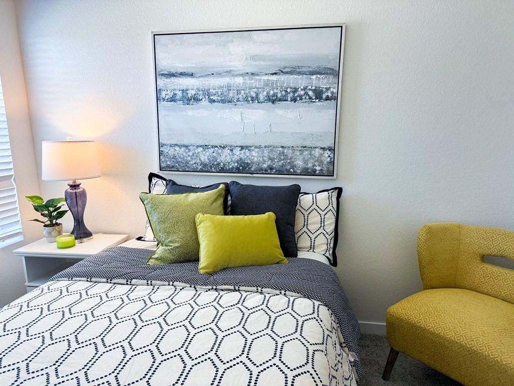 a bedroom with a bed and a yellow chair