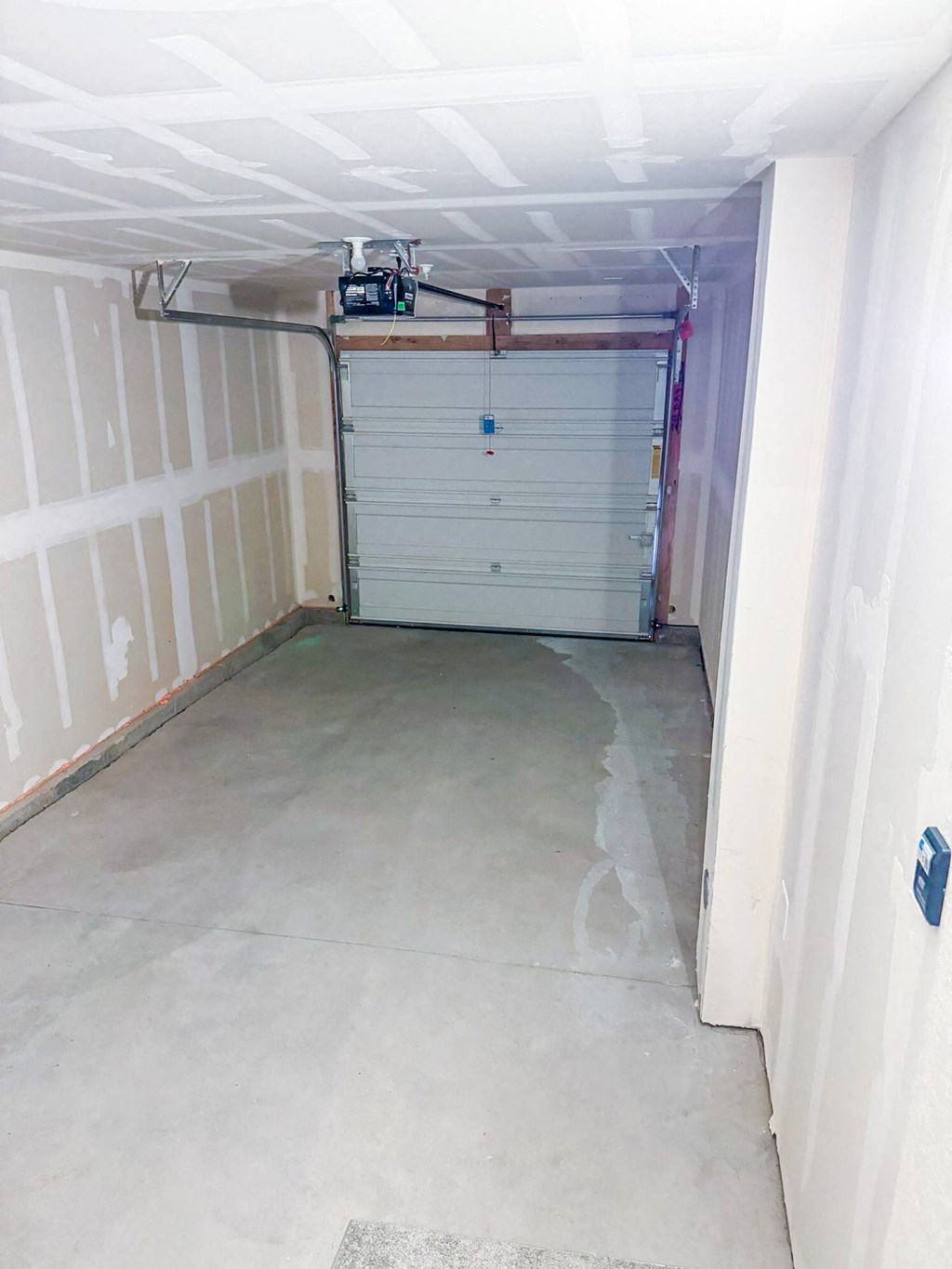 a garage with white walls and a gray floor and a garage door