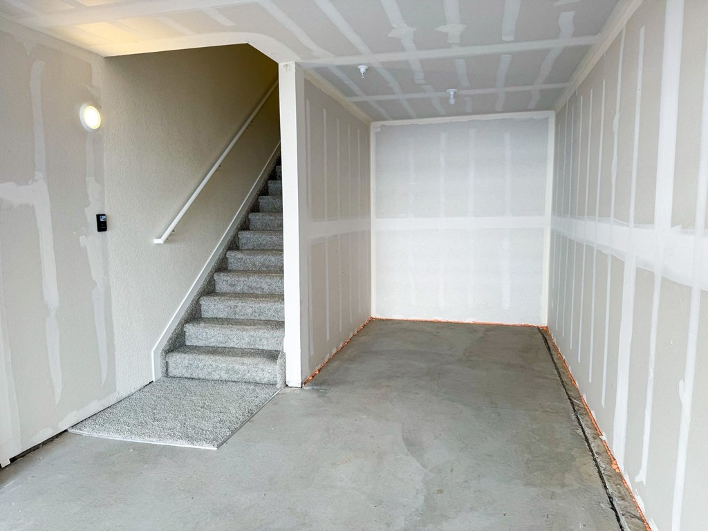 an empty room with stairs and a white wall