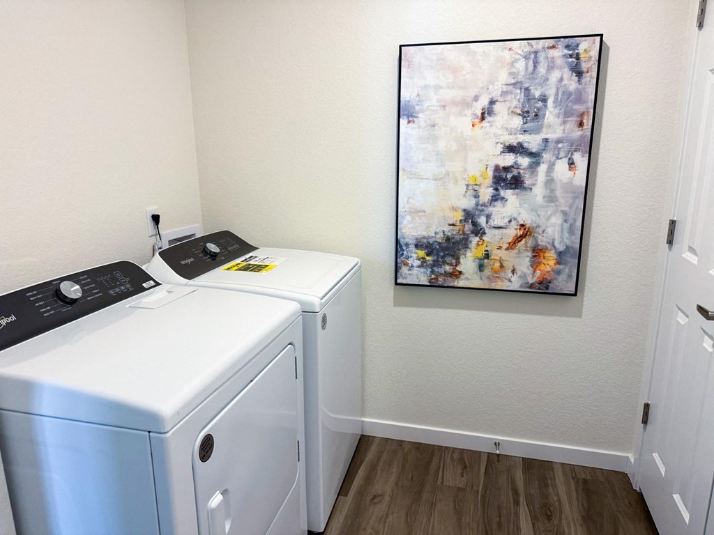 a laundry room with two washers and a painting on the wall