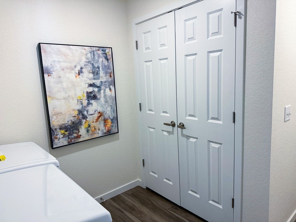 a bathroom with a white door and a painting on the wall