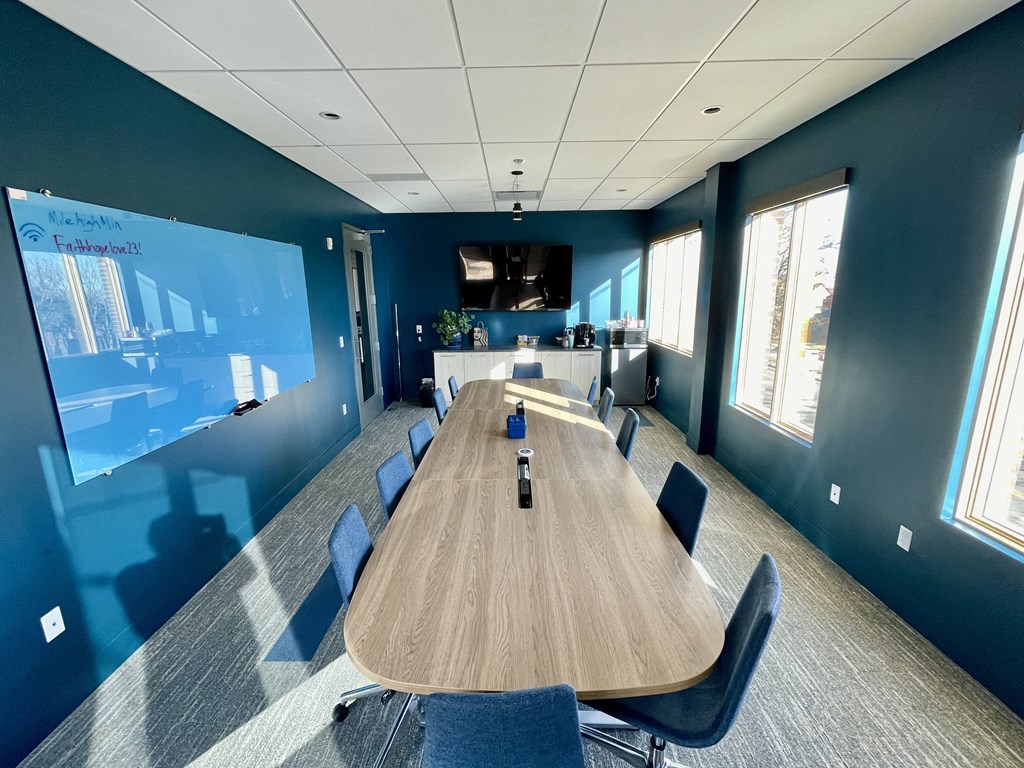 a large conference room with a table and chairs and a tv
