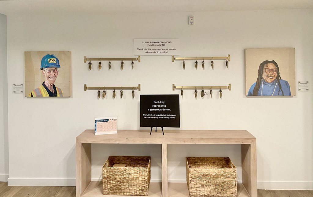 a table with two baskets and two portraits of people on the wall