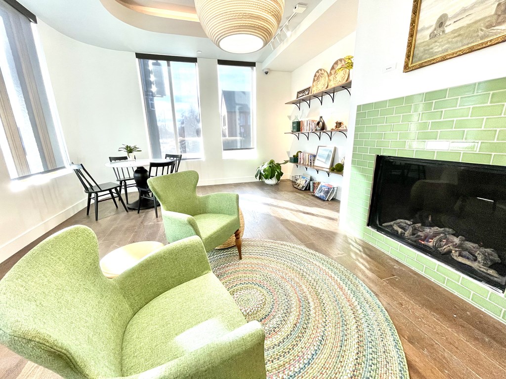 a living room with green chairs and a fireplace