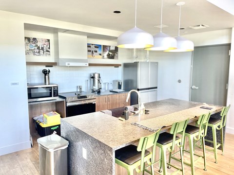 a view of a kitchen with a large island with green chairs