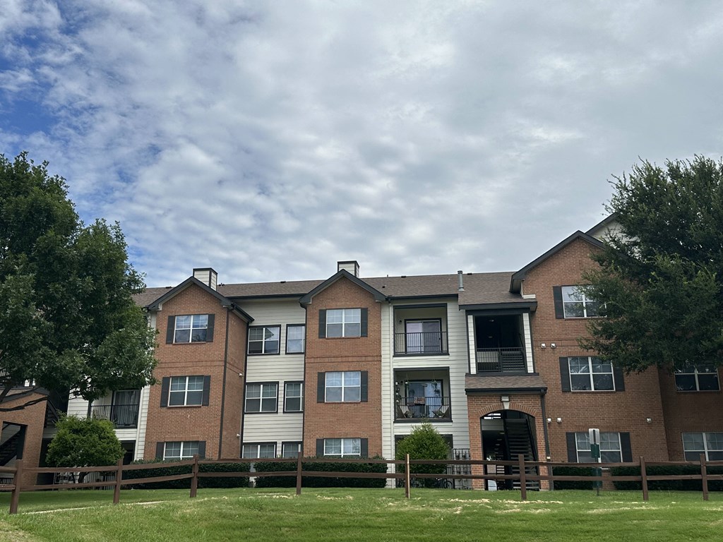 an apartment building with a cloudy sky in the background