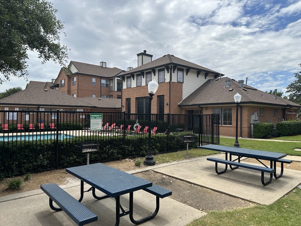 a park with picnic tables in front of a building
