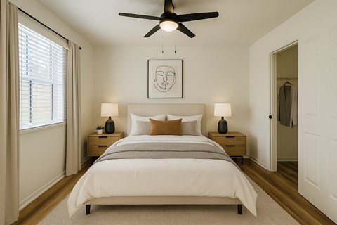 A bedroom with a large bed and a ceiling fan.