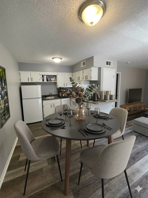 A dining room with a table set for four.