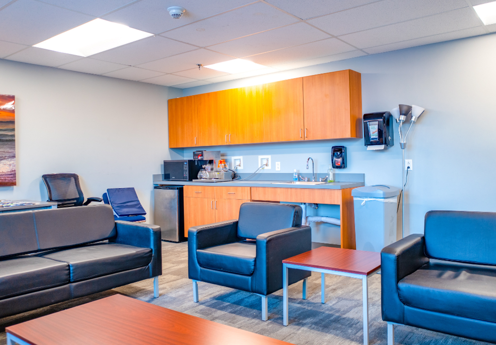 a living room with a kitchenette and couches
