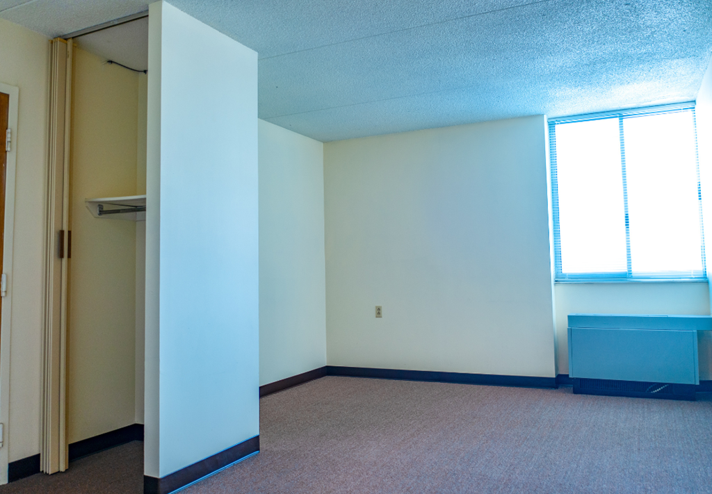 an empty room with a closet and a window