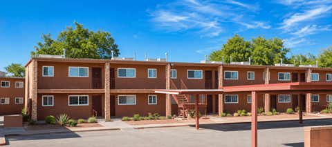 Apartment complex with brown buildings and a clear blue sky.