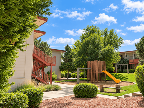 A playground area with a slide and a climbing structure.