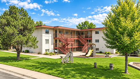 A white building with a red staircase in front of it.