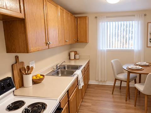 A kitchen with wooden cabinets and a white stove top oven.