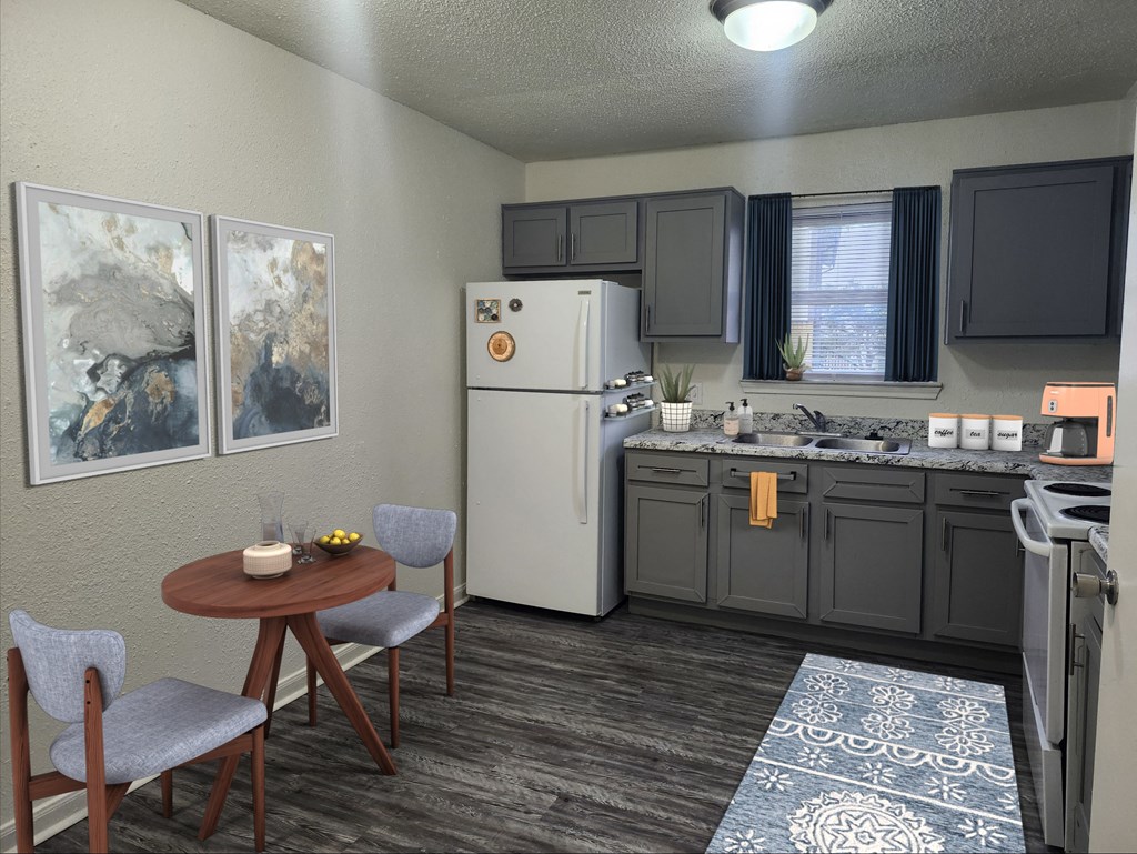a kitchen with a refrigerator and a sink and a table and chairs