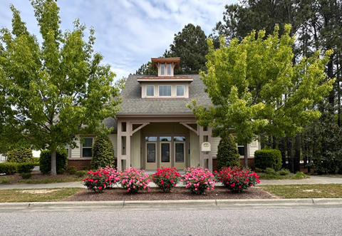 the front of a house with flowers in front of it
