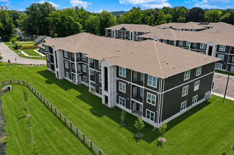 A large apartment complex with a green lawn in front.