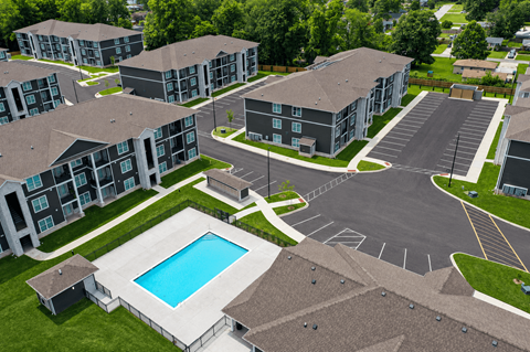 A swimming pool is surrounded by apartment buildings.