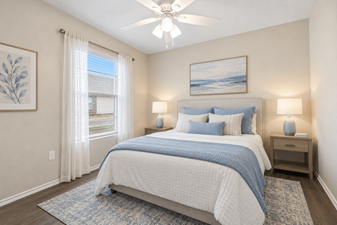 A bedroom with a large bed and a ceiling fan.