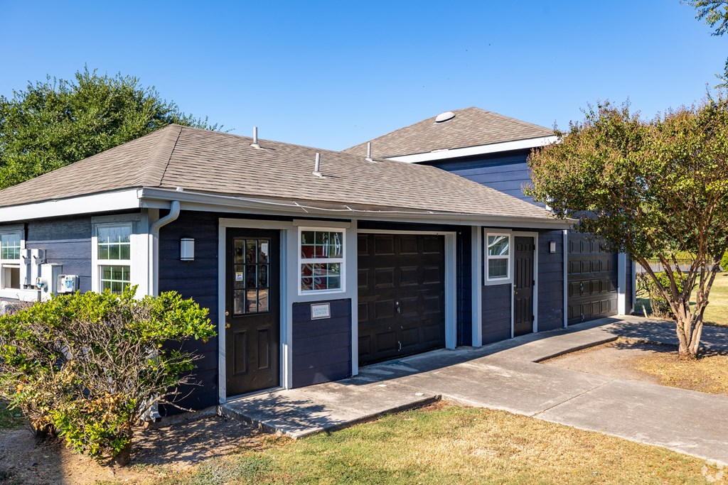 A house with a brown roof and a grey garage door.