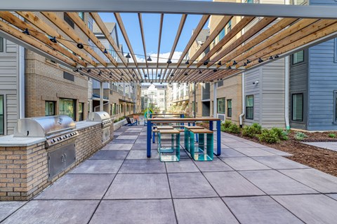 A long covered walkway with benches and a brick wall on one side.