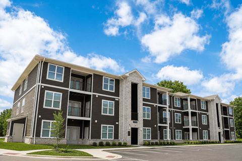 A large, modern apartment building with multiple balconies and doors.