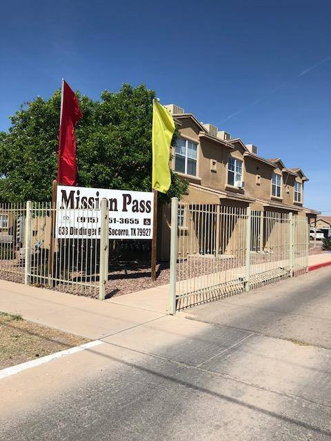A sign for Mission Pass in front of a building.
