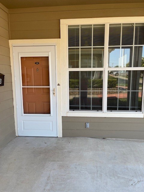 A brown door is on the left and a window with blinds is on the right.