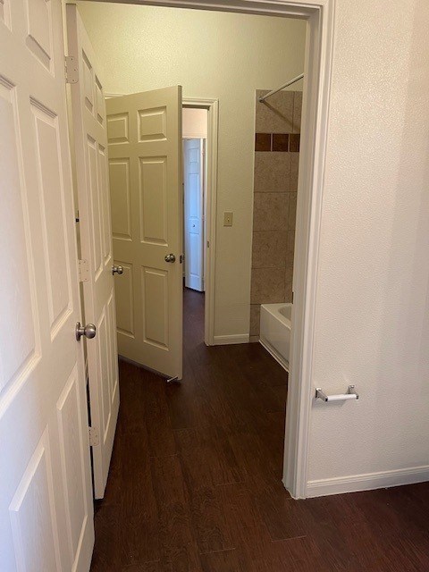 A hallway with white doors and a white wall.