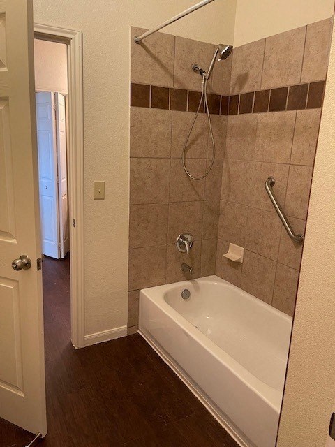 A white bathtub with a shower head and a shower curtain rod.