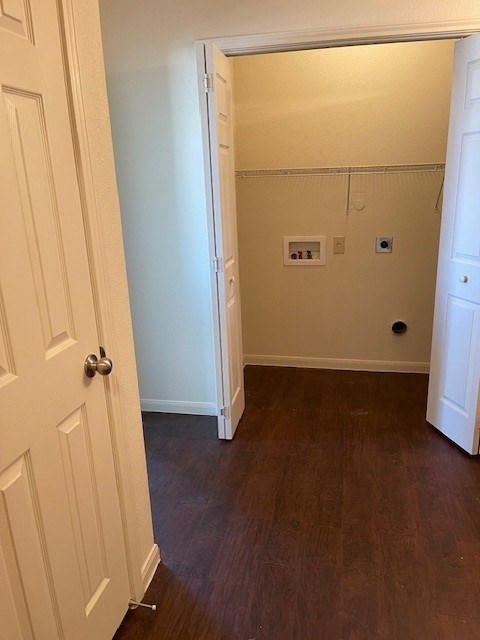 A white door is open to a room with a brown floor.