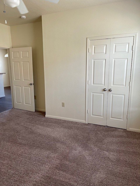 A room with two white doors and a ceiling fan.