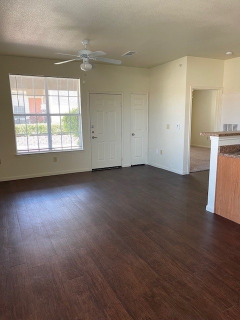 A room with a ceiling fan and wooden flooring.